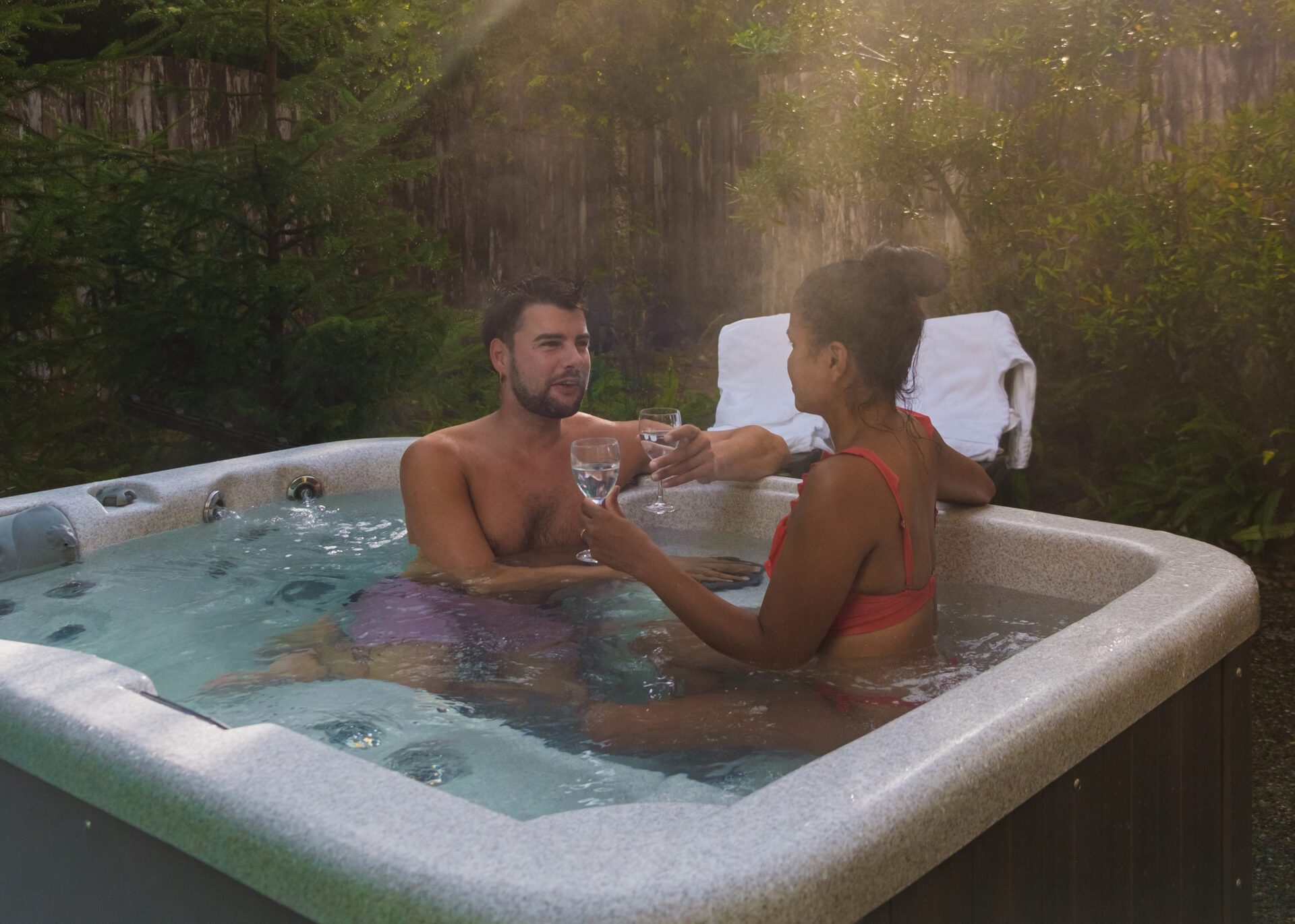 couple in hot tub bath in the rain forest of Vancouver Island, men and women in jacuzzi Couple Relaxing in Forest Hot Tub